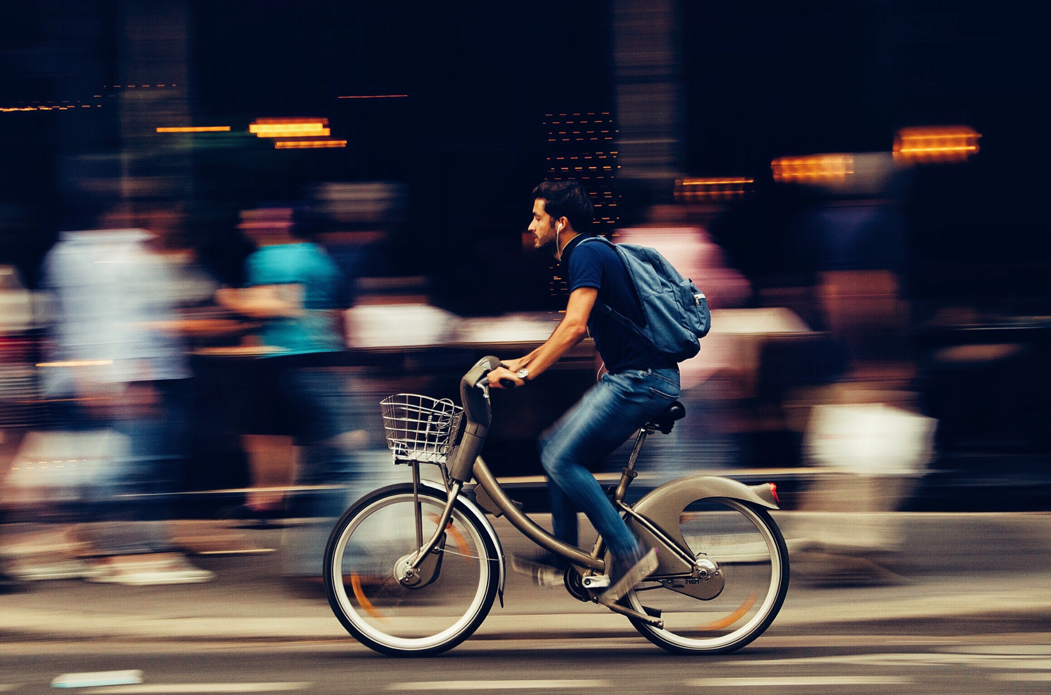Man som cyklar förbi människor